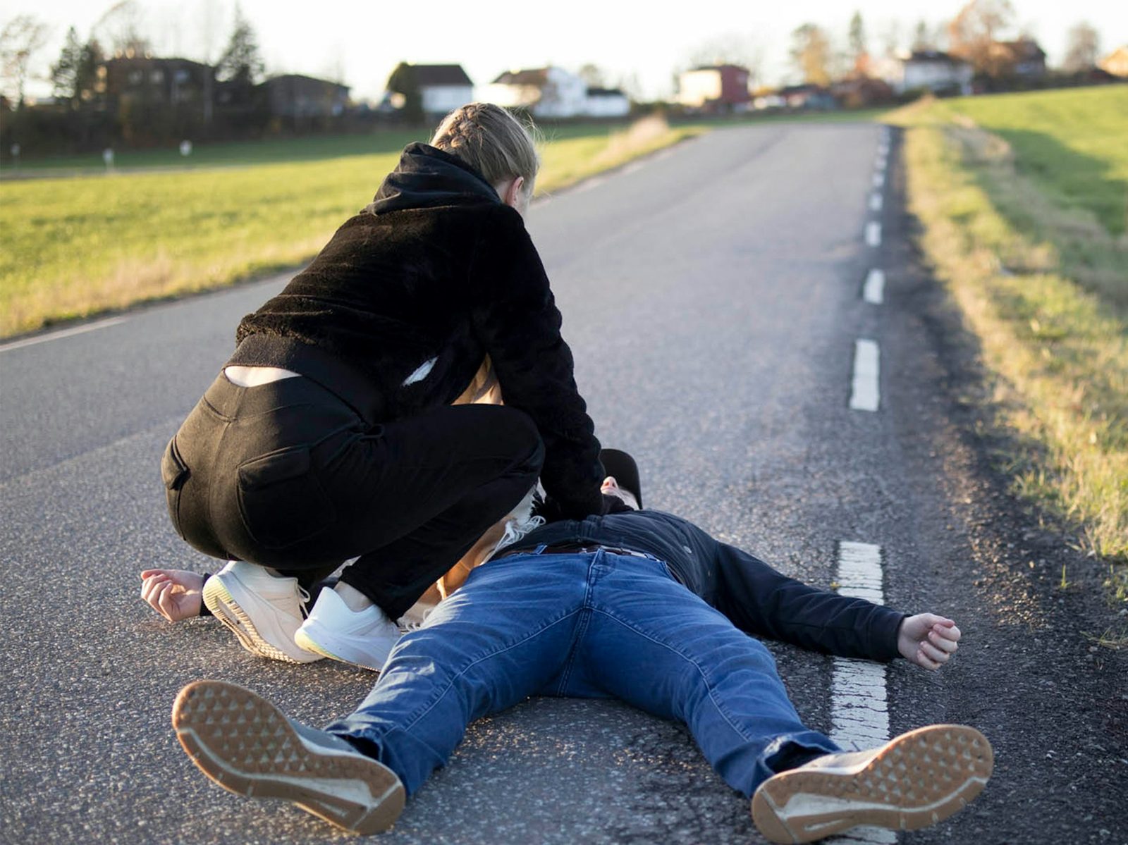 Person yter førstehjelp/HLR ved vegkant